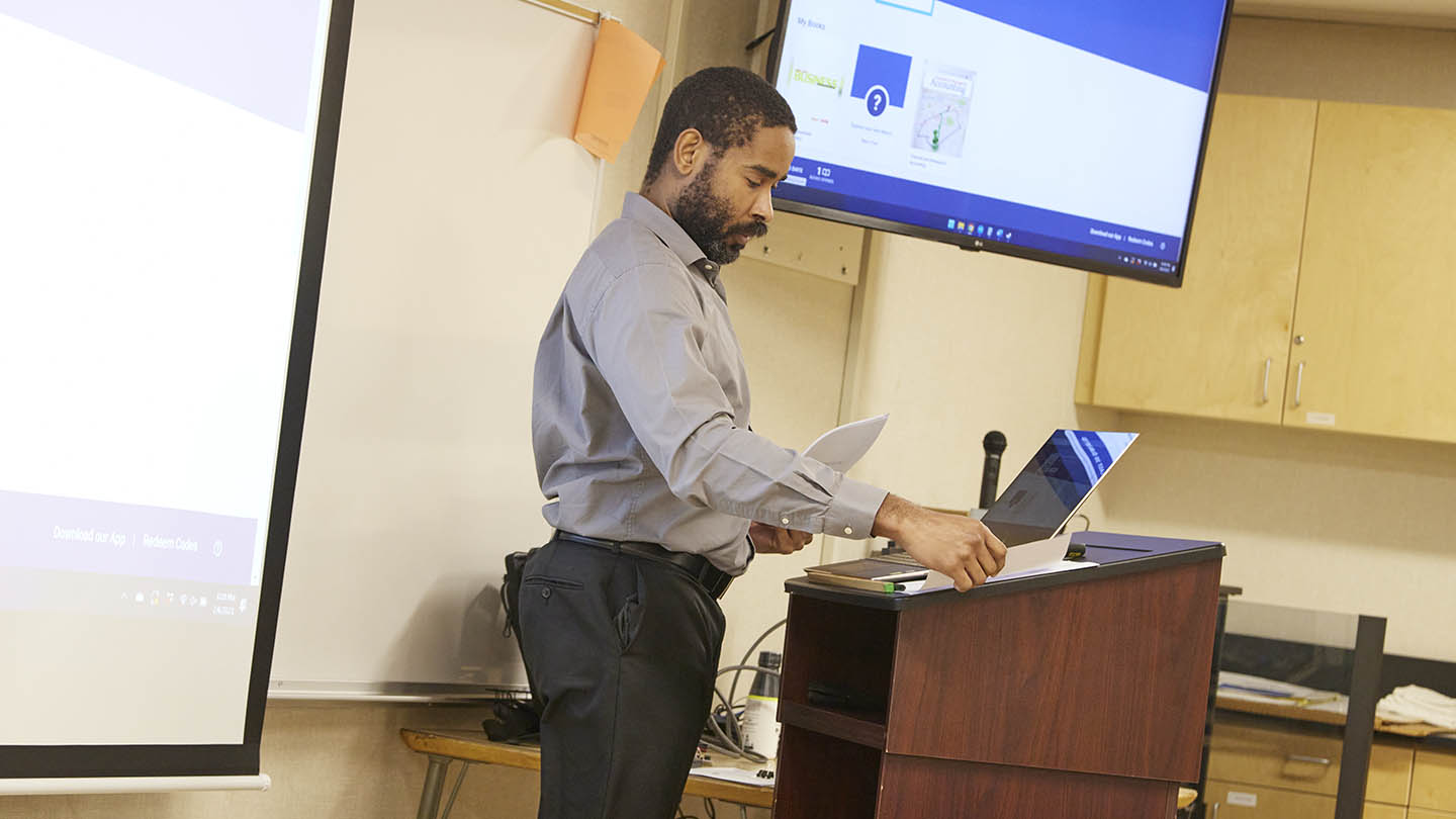 A male professor prepares for his upcoming class.