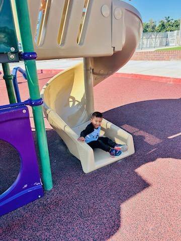 child on playground slide