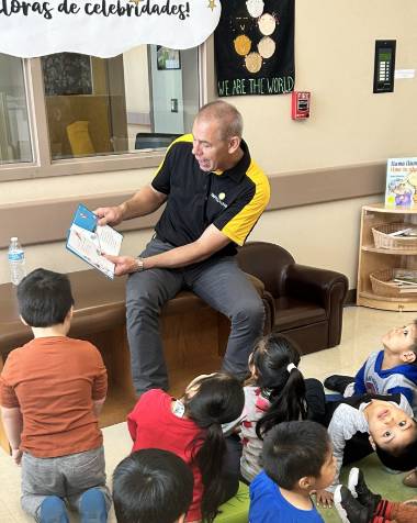 man reading book to young children