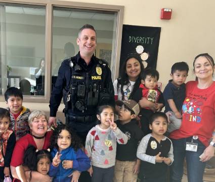 policeman laughing with children and teachers