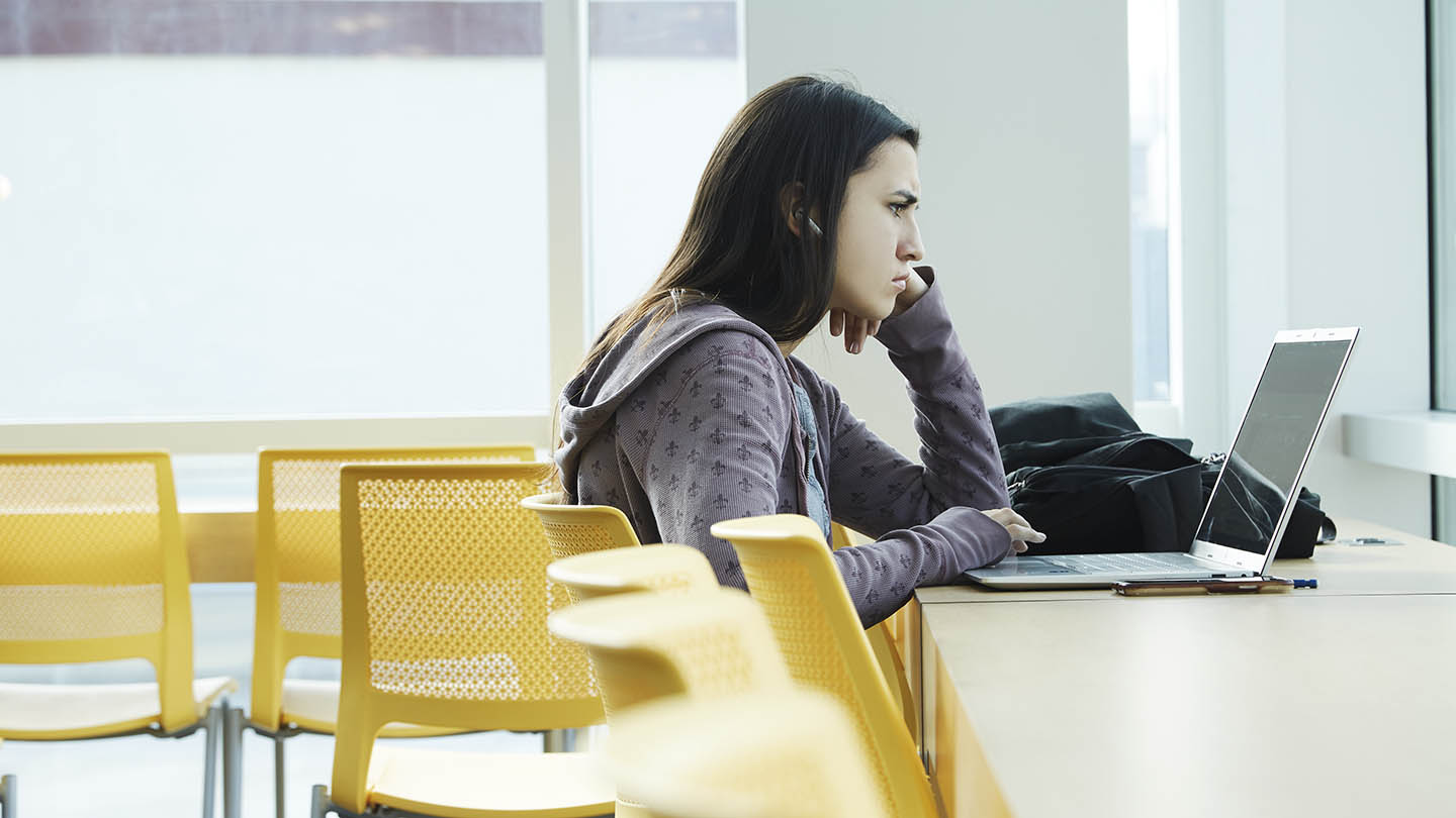 A student alone in the Student Center lounge.