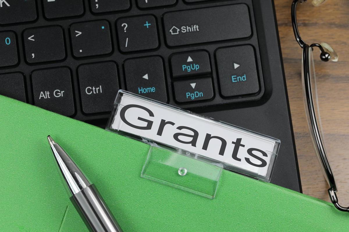 file with "grants" label on laptop keyboard