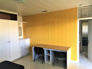 A desk with two chairs is included in each Cougar Dorm room